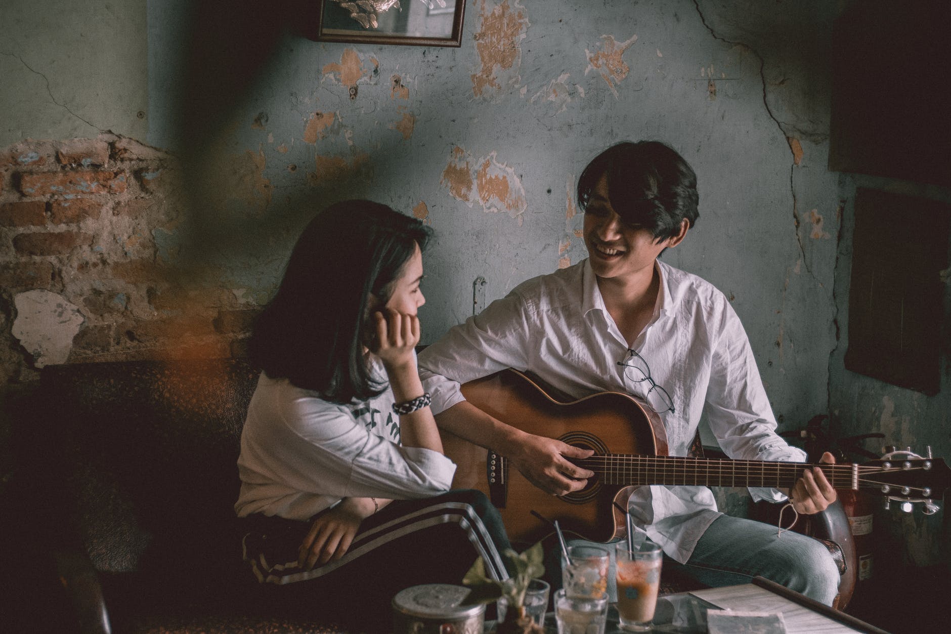 man playing guitar with girl