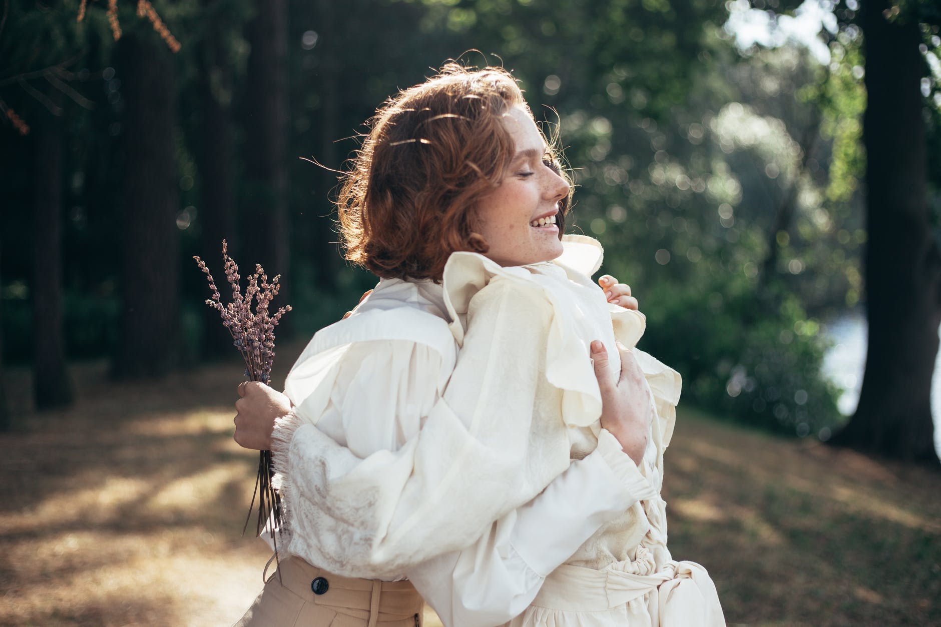 smiling women embracing in park